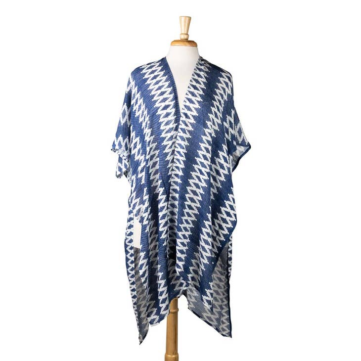 A blue and white poncho-like garment rests on a dressform.