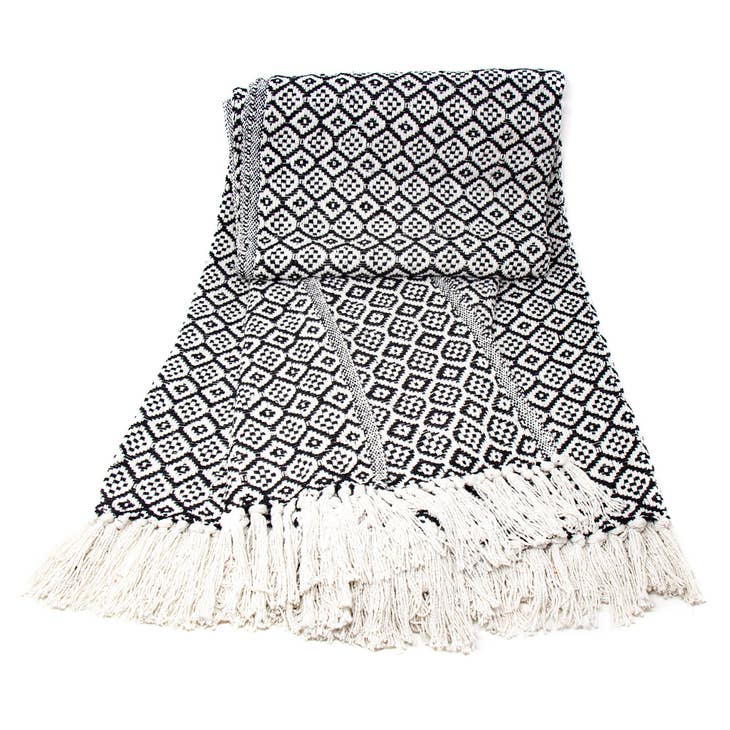 A folded decorative black and white cotton throw