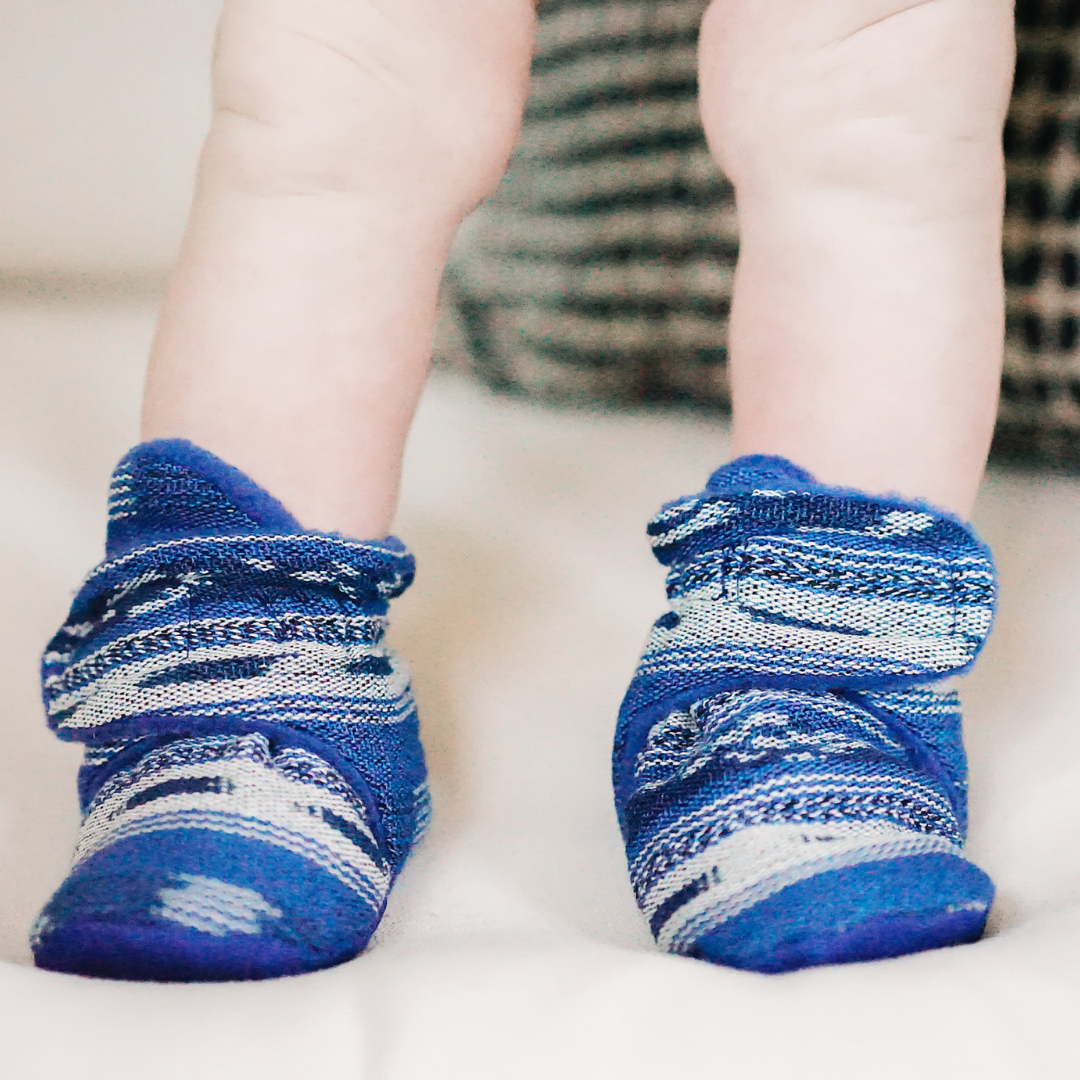 Baby wearing blue ankle booties, Mexican Native American blue and white pattern