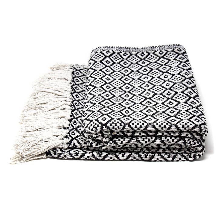 A folded black and white decorative cotton throw